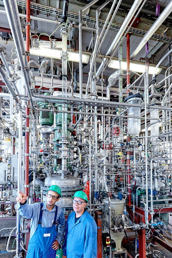 Chemische Industrie. Zwei Männer mit Helm in Technikum