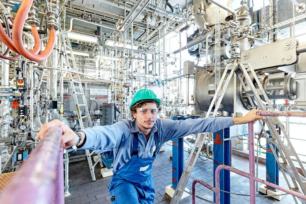 Portrait eines Mitarbeiter der chemischen Industrie vor chemischer Anlage